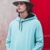 boy with a hat and teal hooded sweatshirt looking to the side